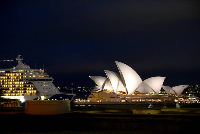 Cruise ship at night next to the Sydney Opera House