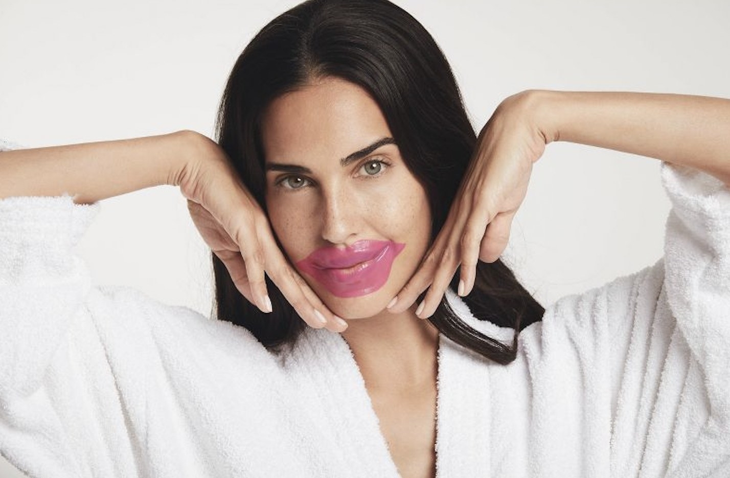 A person wearing a pink lip mask