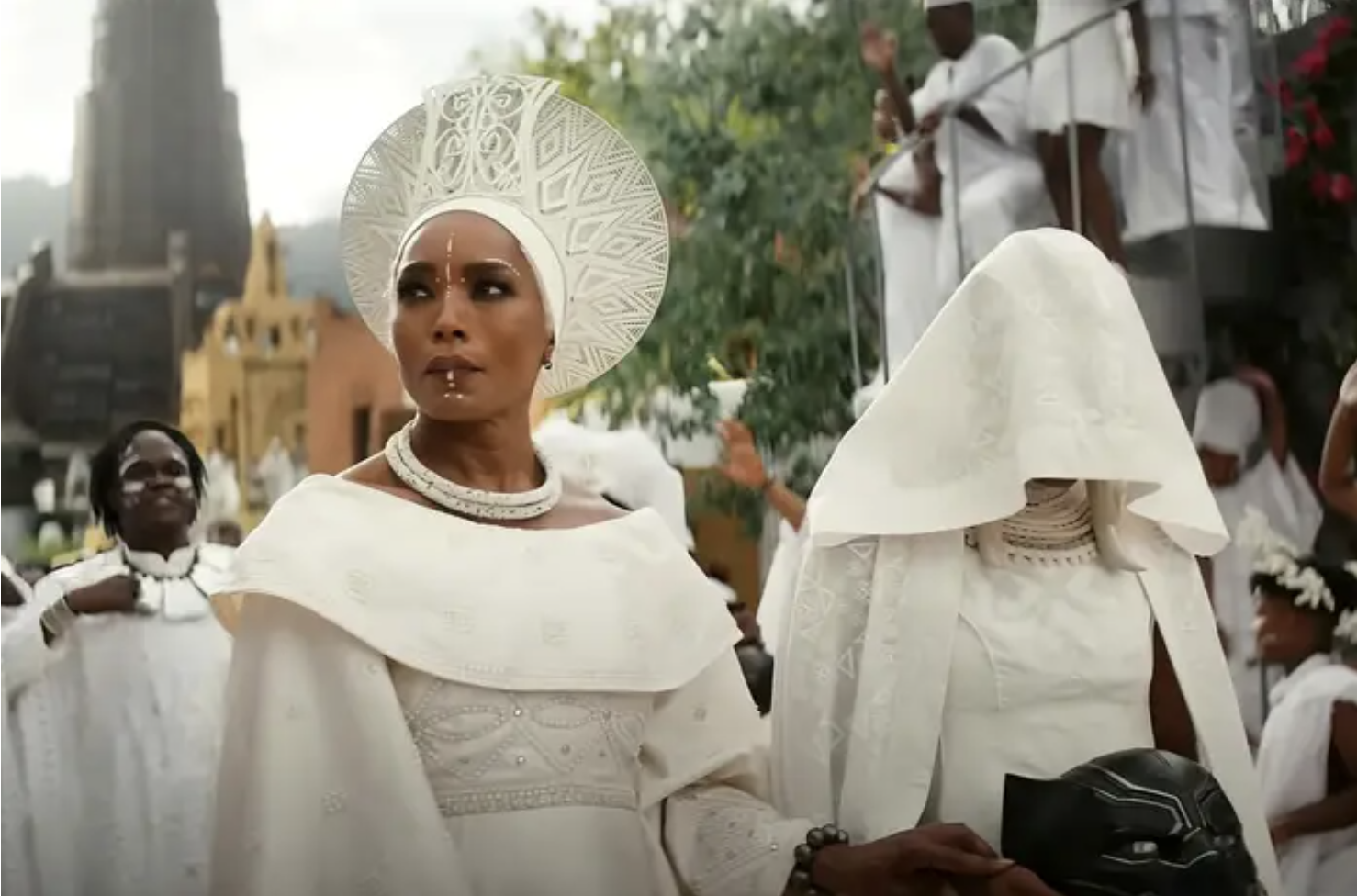 angela bassett in white mourning clothes standing next to another hooded person in white 