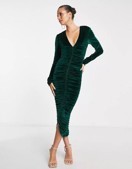 Model standing cross legged in the green dress
