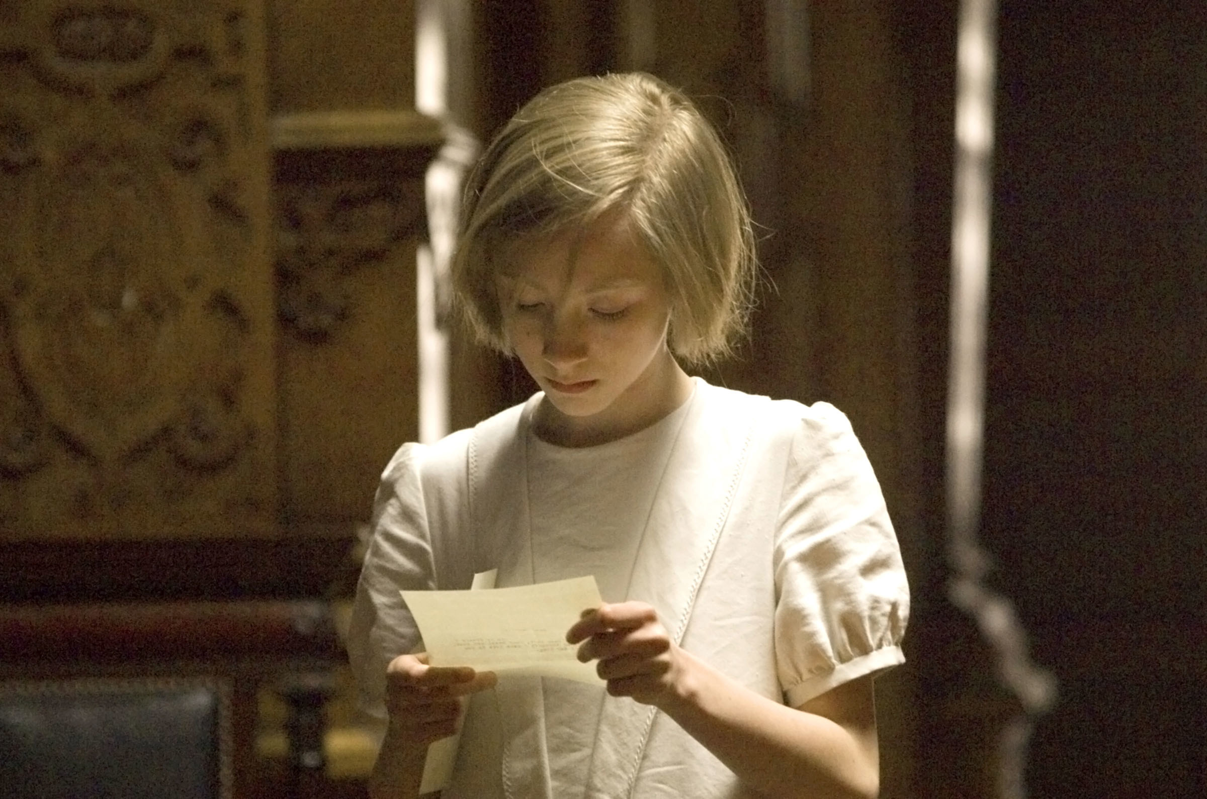 A young girls reading a letter