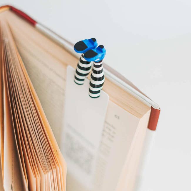 the bookmark with 2 legs that person striped stockings and bluish shoes connected the extremity wrong of a book