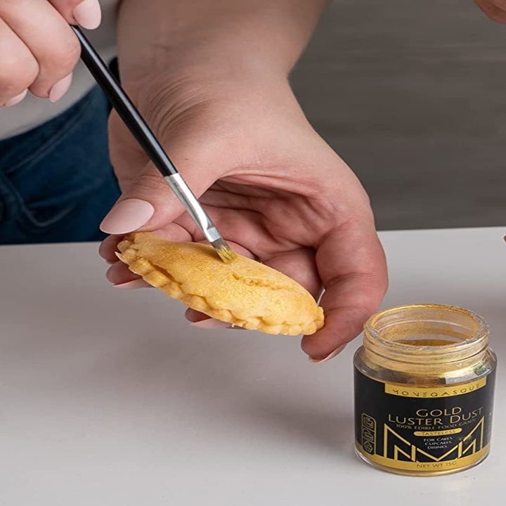 A person putting the dust onto a dessert