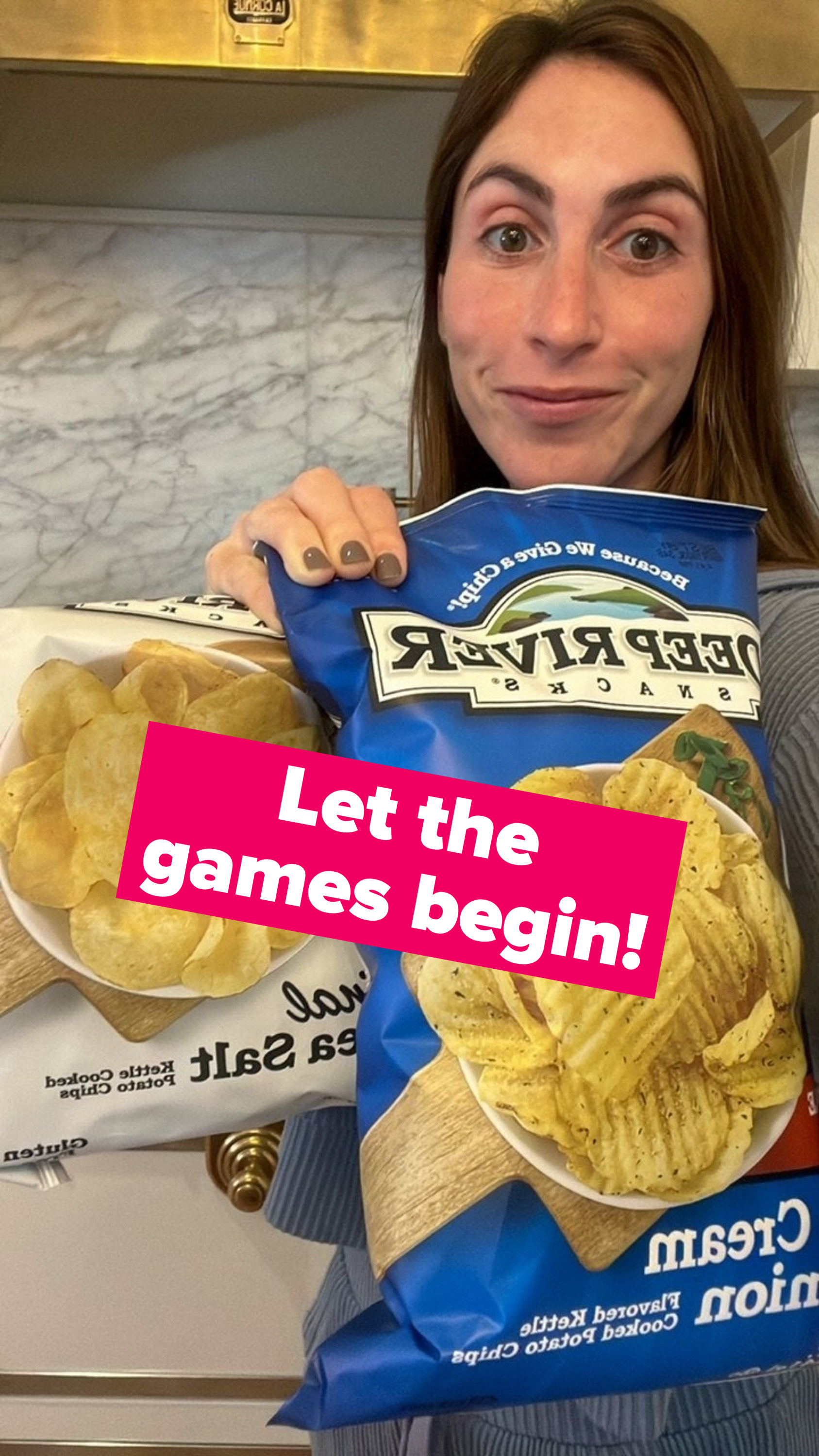 A woman holding two bags of potato chips.