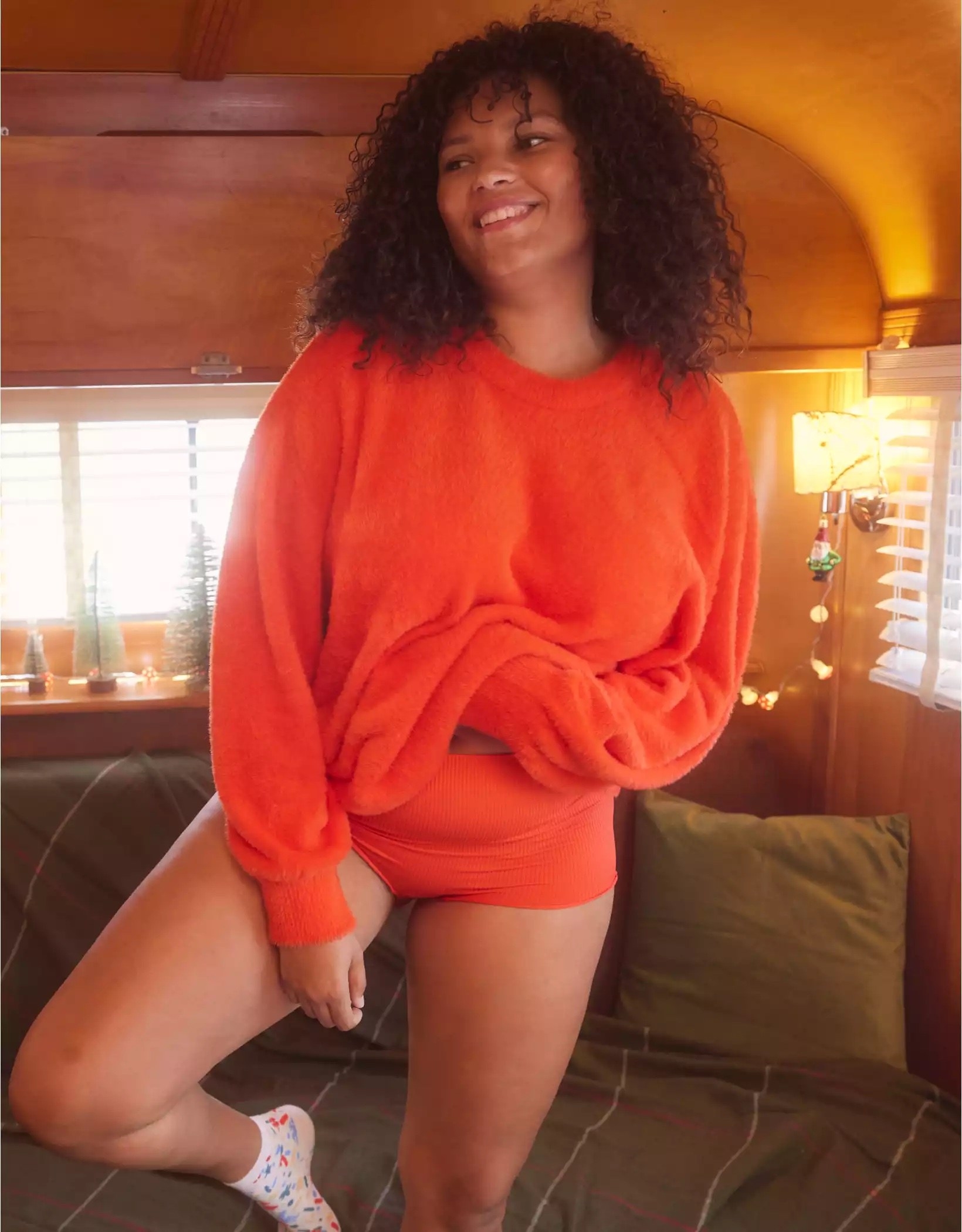 Model wearing bright orange top with bottoms