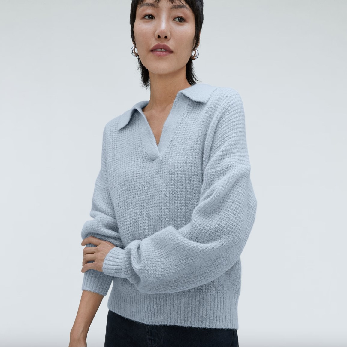 Model wearing blue sweater with black pants