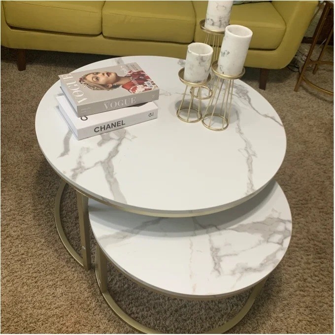 The nesting tables with three candles and two coffee table books on top