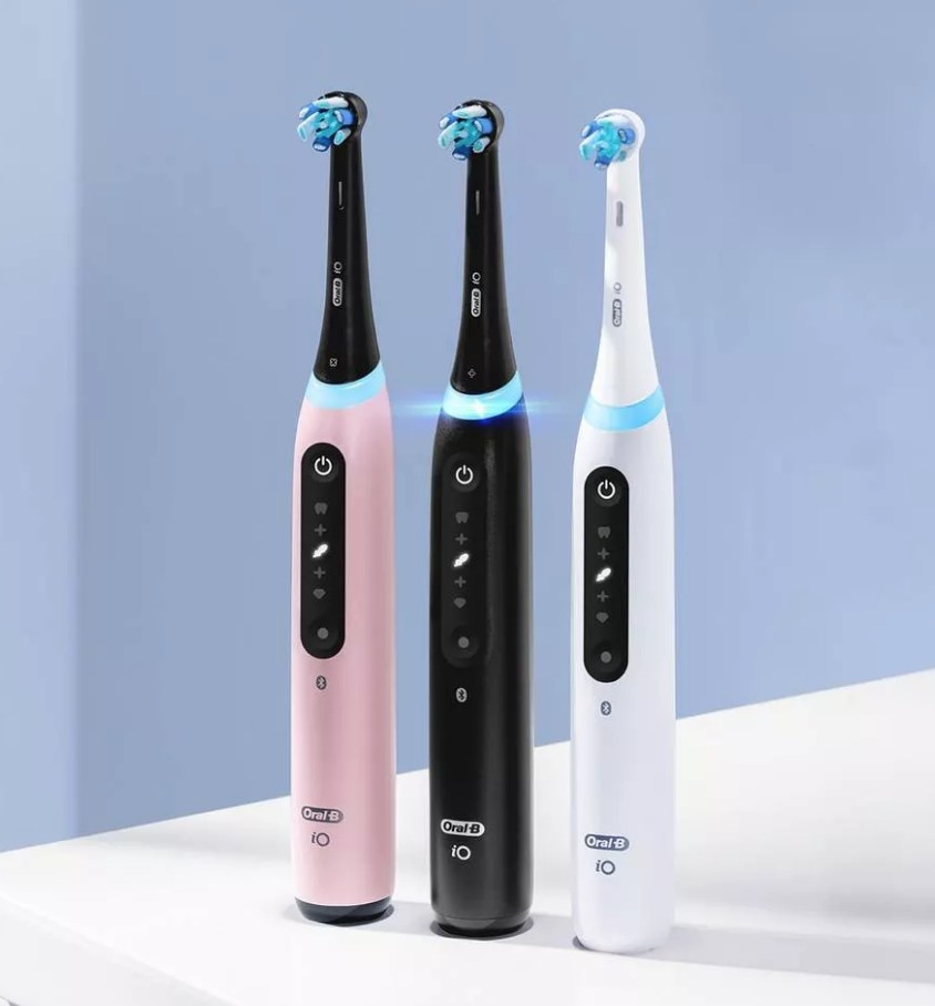 Pink, black, and white electric toothbrushes