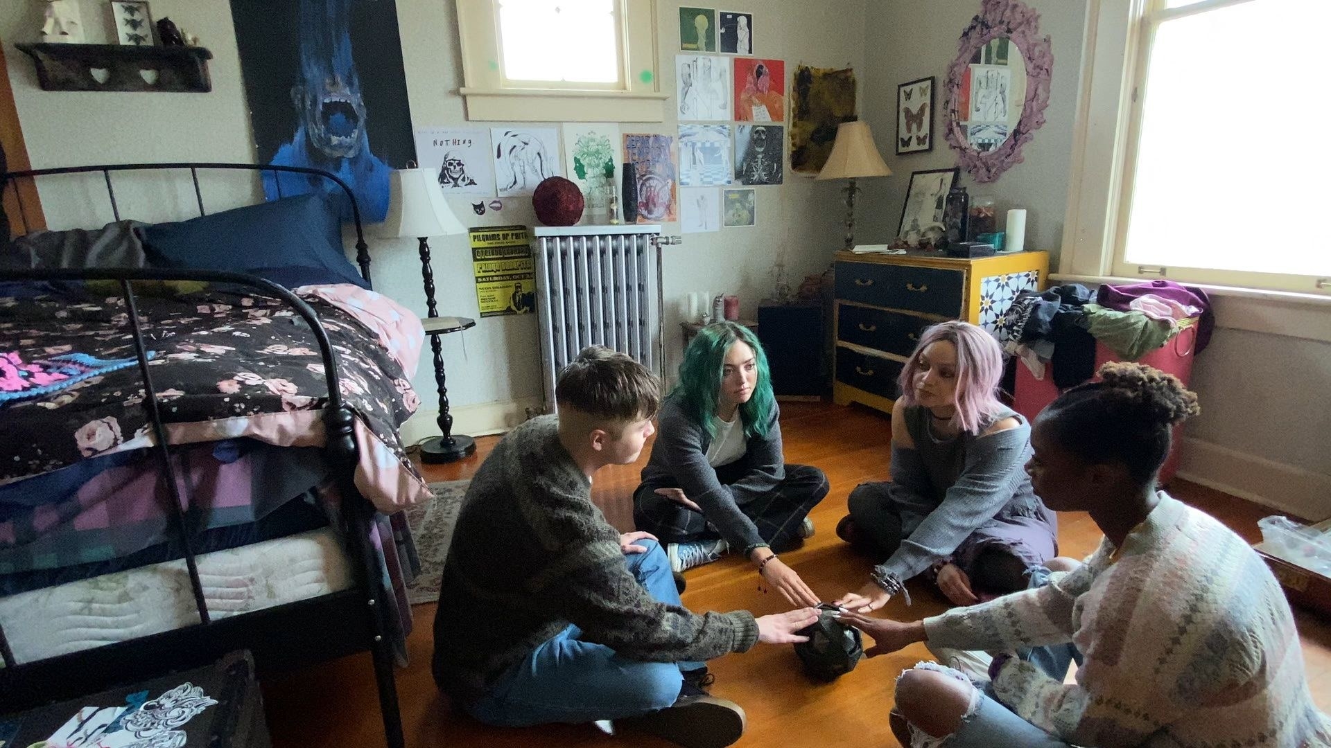 Zooza and friends sitting in a bedroom with their hands on a ball