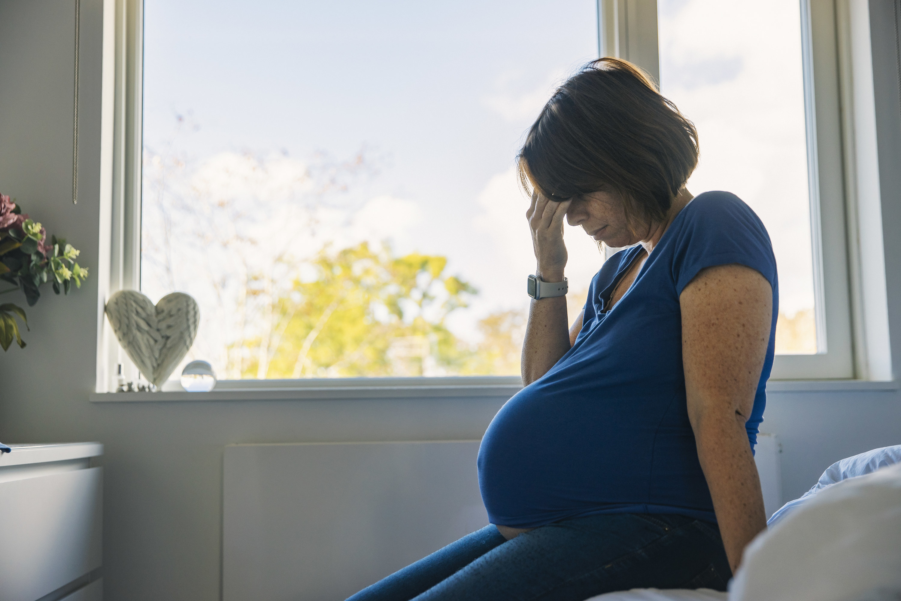 a pregnant woman sitting in her room