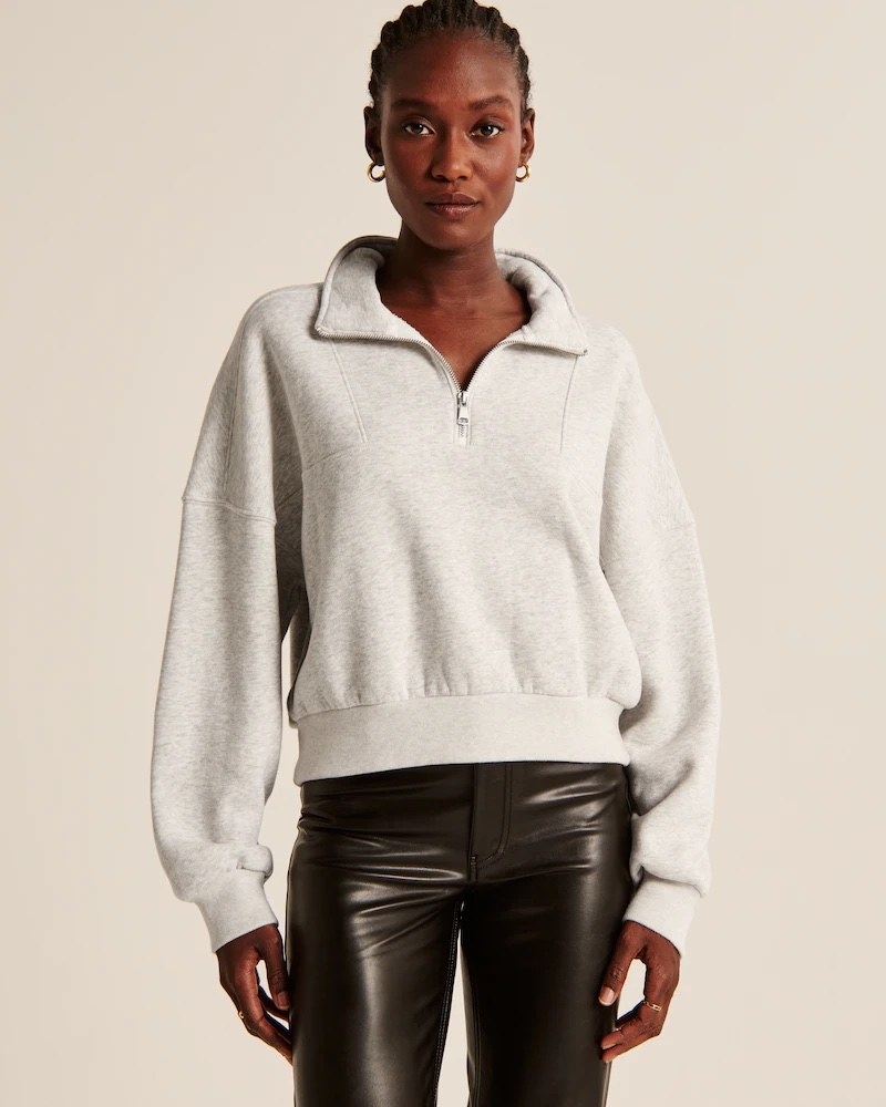 Model wearing grey quarter zip with black pants
