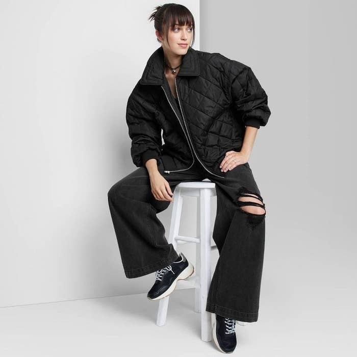 model wearing black quilted bomber with black pants