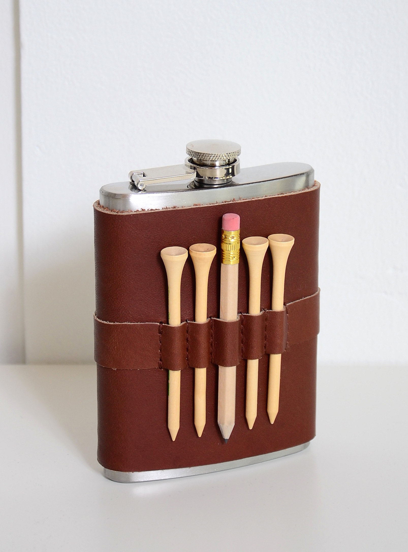 the flask with a pencil and four tees