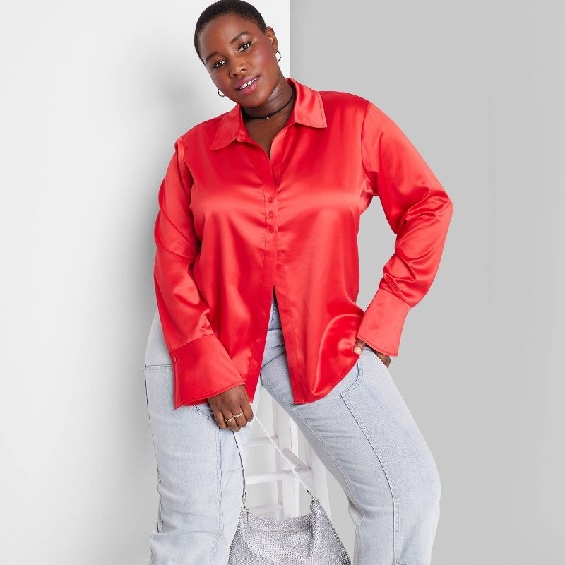 model wearing red satin button down with gray pants