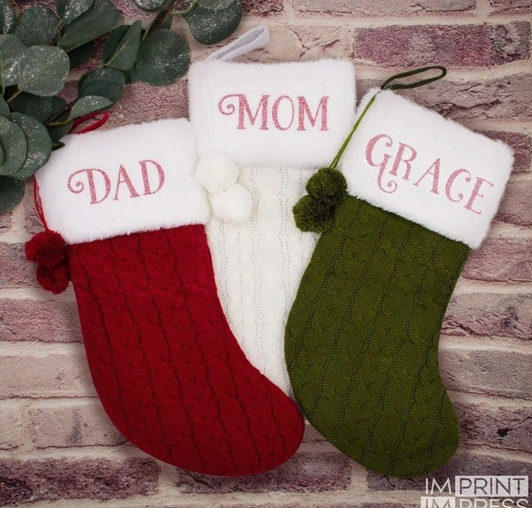 a red stocking labeled &quot;dad&quot;, a white one labeled &quot;mom&quot;, and a green one labeled &quot;grace&quot;