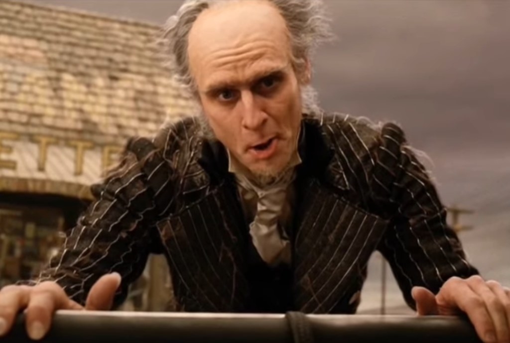 Jim Carrey as Count Olaf talking to someone in a car