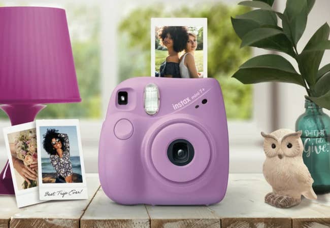 purple Instax Mini 7+ small camera printing out photo of two friends