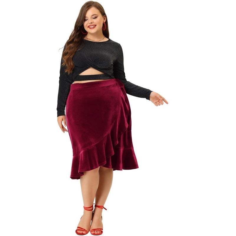 model wearing burgundy velvet wrap skirt with black top and red heels