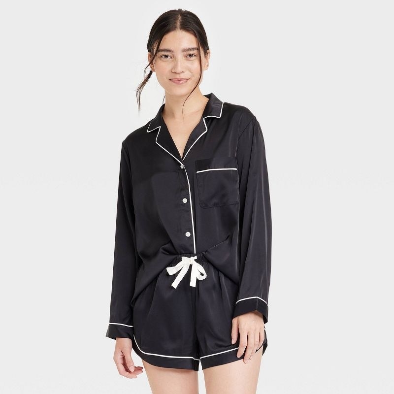 model wearing black and white satin pajama set with top and shorts
