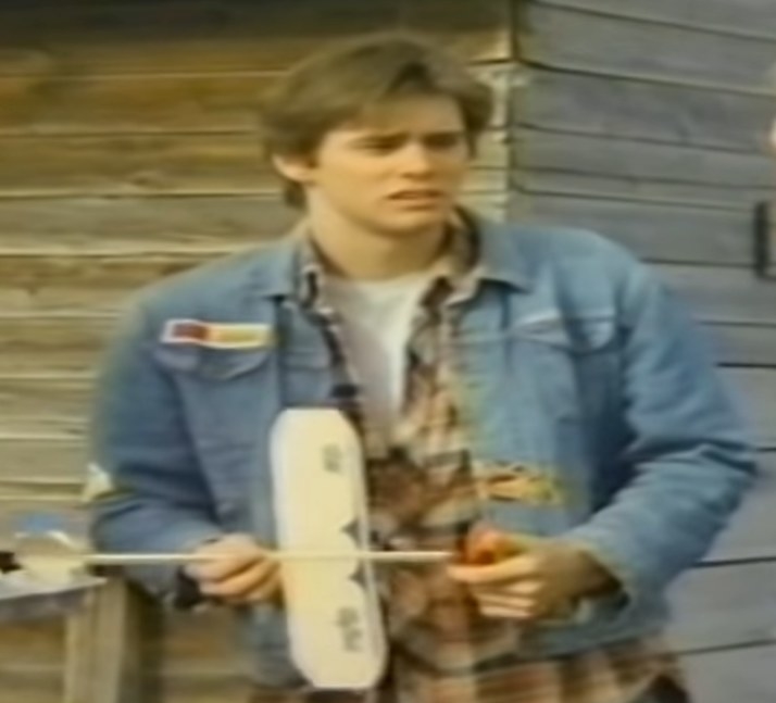 Jim Carrey Lane holding a toy plane looking confused