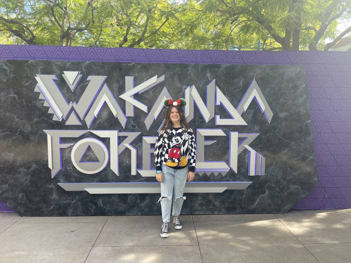 the author&#x27;s daughter standing by the Wakanda Forever wall