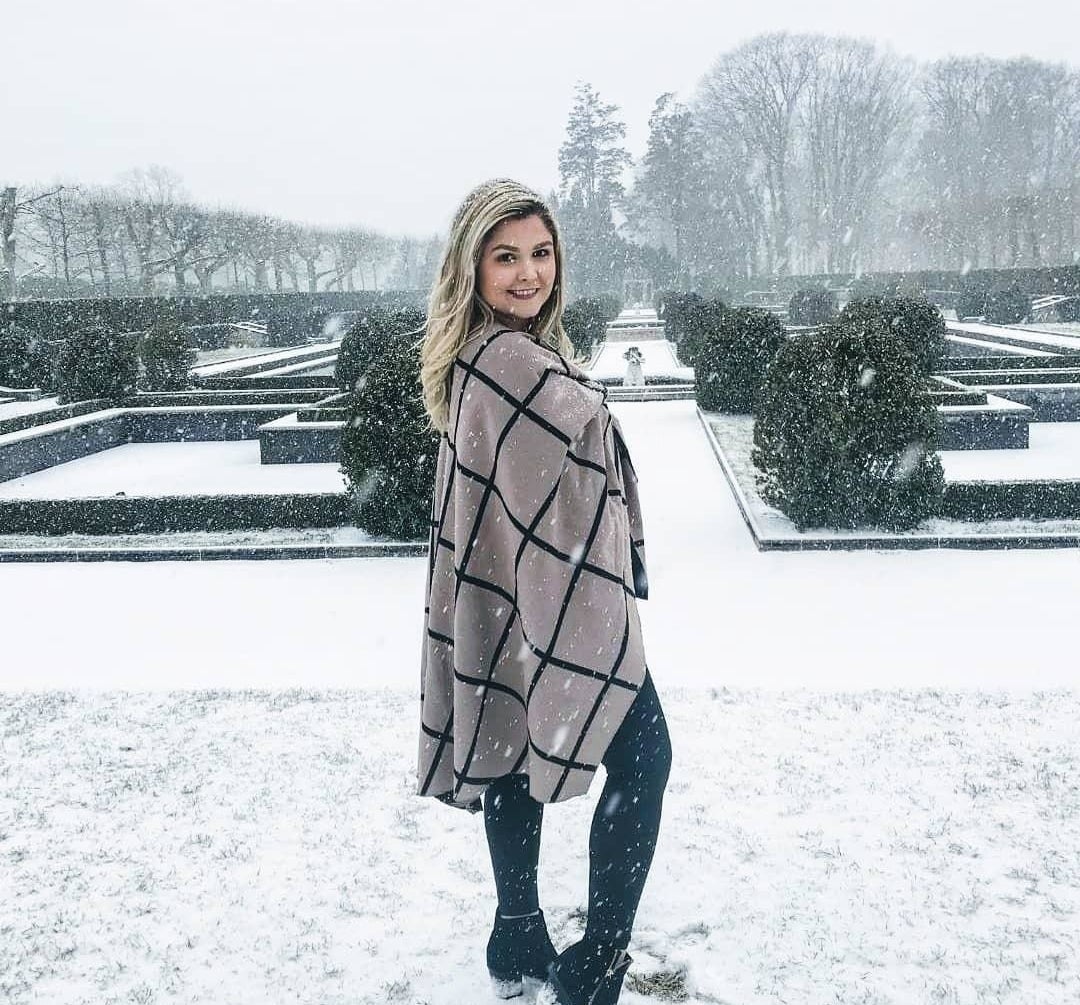 Reviewer standing out in the snow in the white and black plaid shawl
