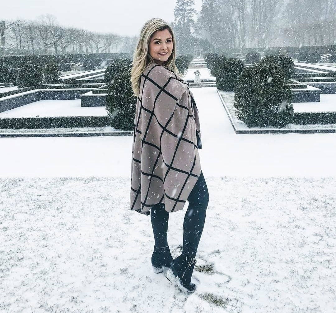 Reviewer standing out in the snow in the white and black plaid shawl