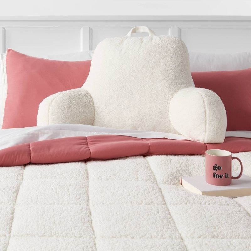 the cream colored bed rest pillow on a bed