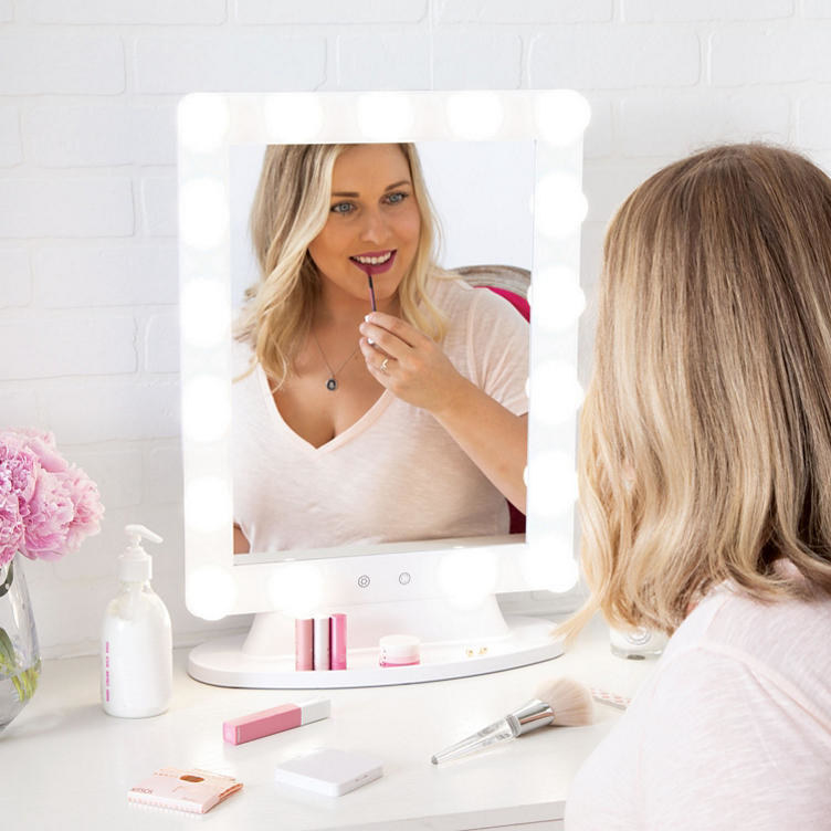 A model applying lipstick in the white mirror