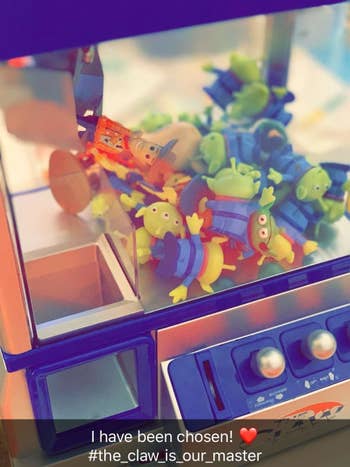 a reviewer's claw machine filled with Toy Story toys