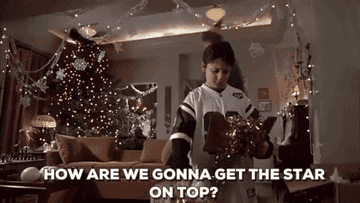 a gif of will ferrel as elf jumping into the christmas tree