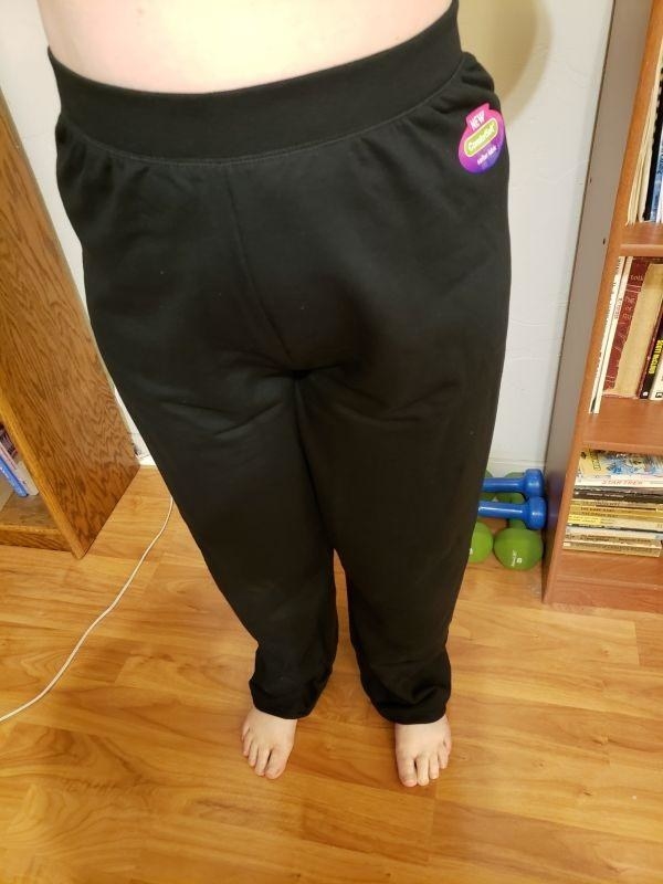 A reviewer wearing a pair of black sweatpants