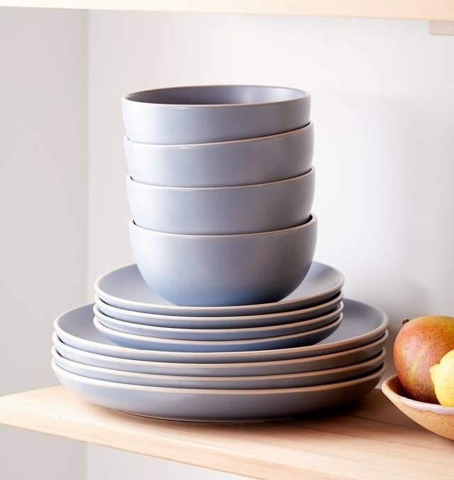 four bowls, for side plates, and four dinner plates stacked on a shelf