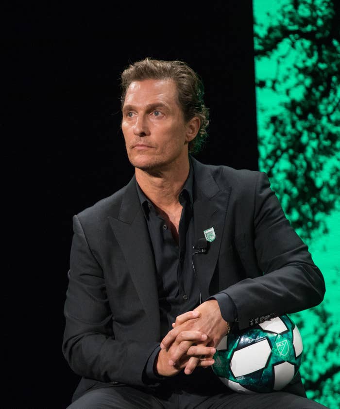 Matthew sitting onstage while holding a soccer ball