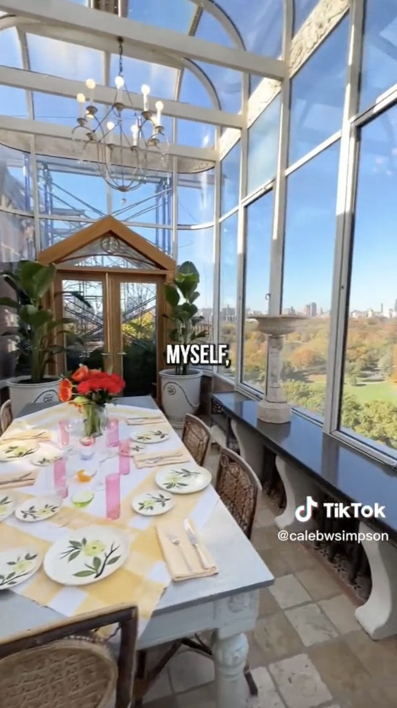 A beautifully set dining table with floral printed plates and a flower arrangement in the center