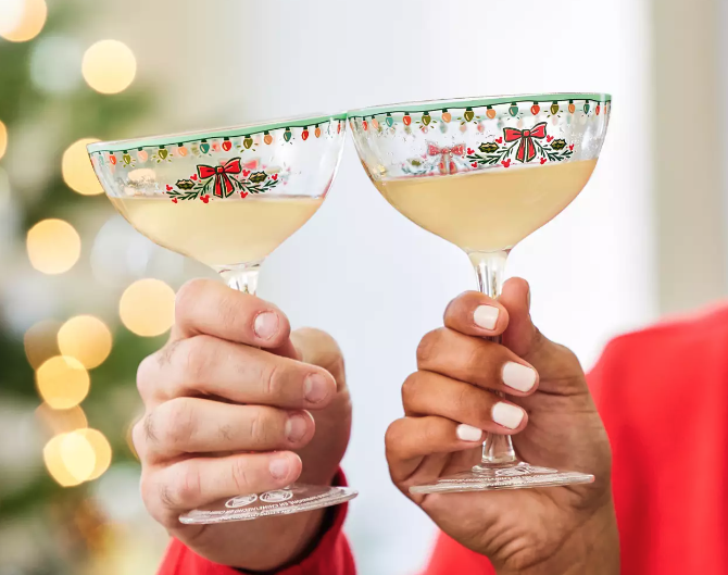 two dessert glasses with a subtle disney holiday design around the rim