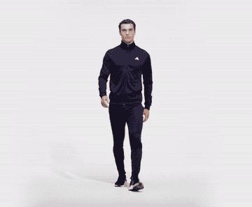 person standing and turning with the tracksuit on to show different features