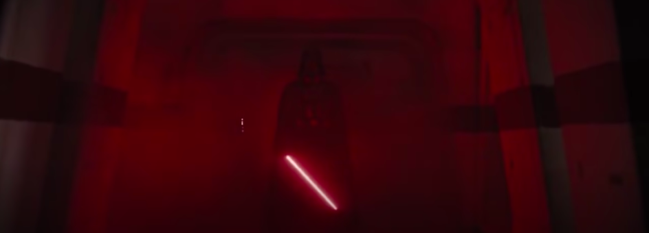 Darth Vader stands in a dark hallway
