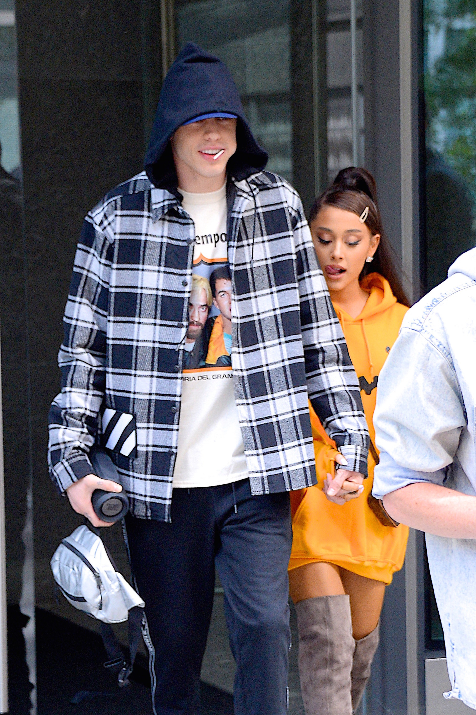 The former couple walking out of a building together while holding hands
