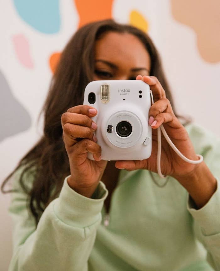 a person holding an instax camera