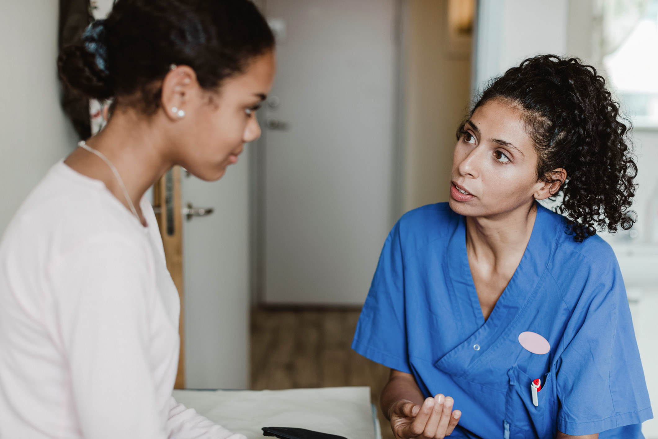 A woman speaking to a nurse