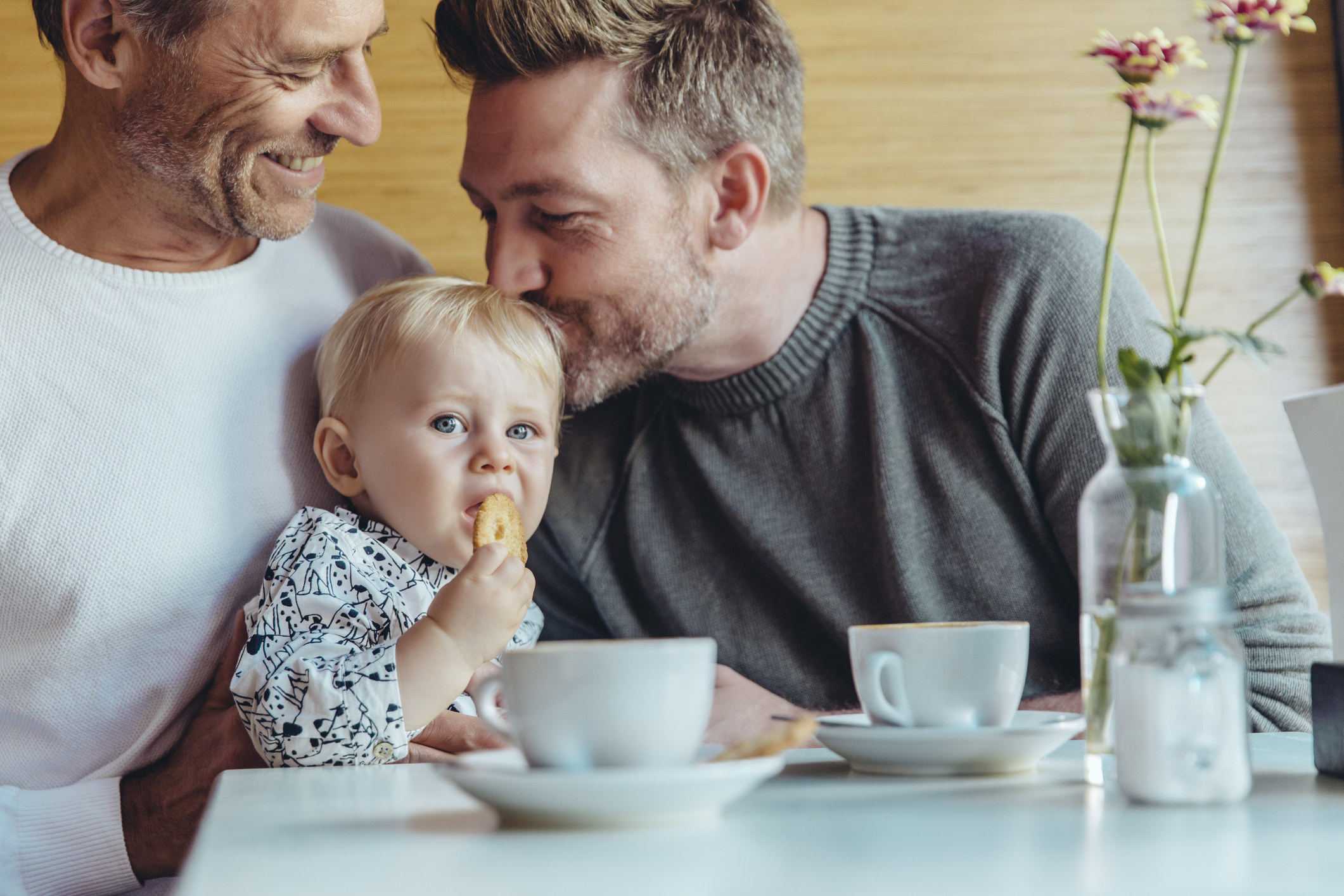 A gay couple doting on their baby