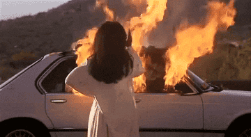 angela walking away from a burning car