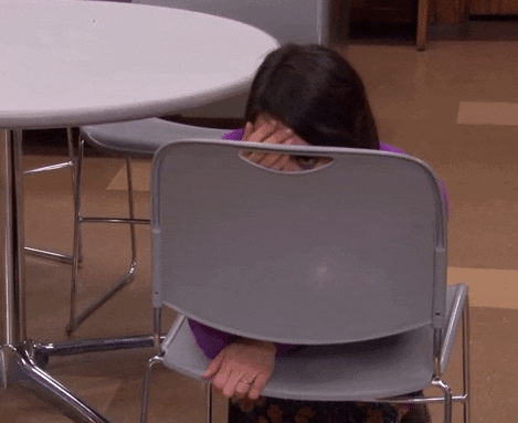 someone hiding behind a chair