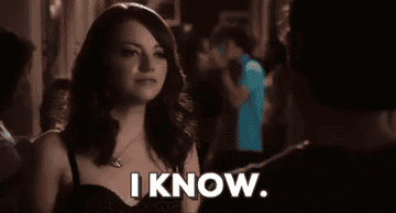 a gif of emma stone saying I know with a sly smile
