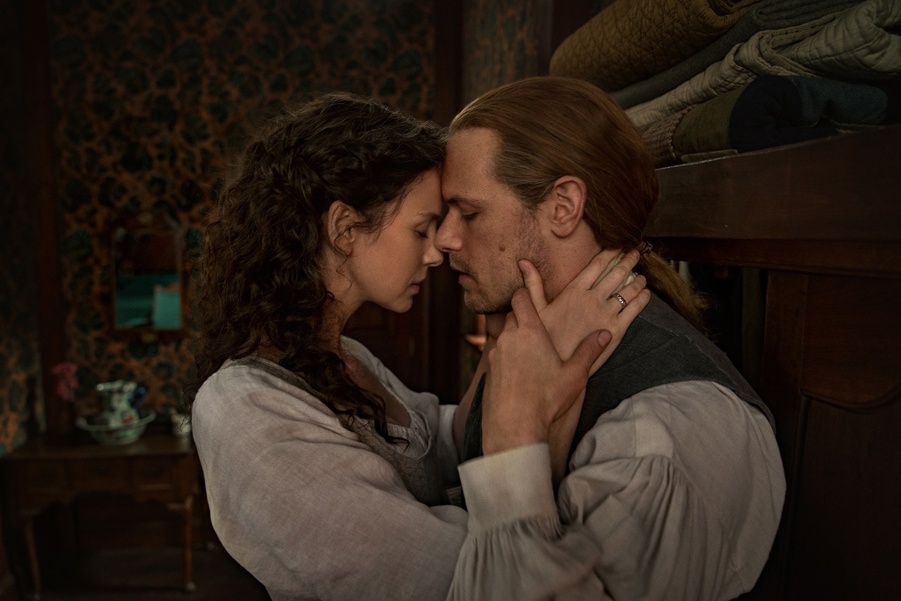 Sam Heughan and Caitriona Balfe embrace in Outlander.