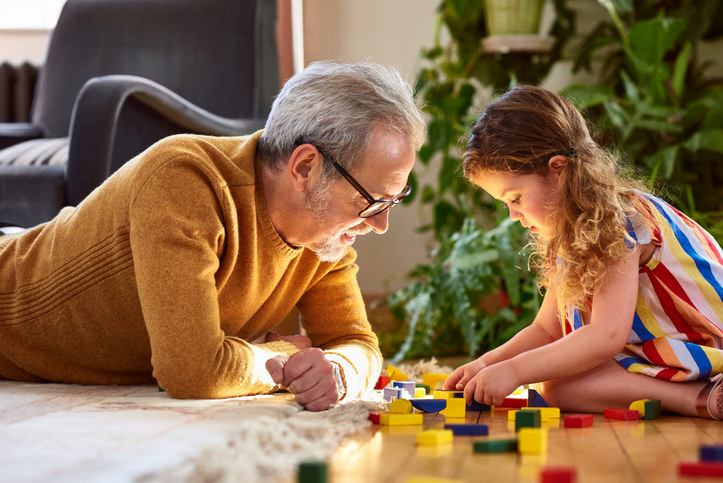 older person and a child playing with toy blocks