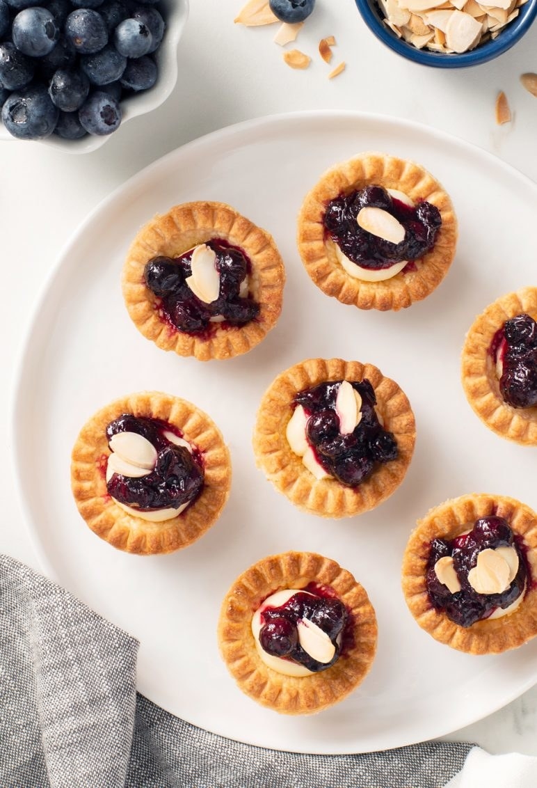 Blueberry brie tartlets sit on a serving tray