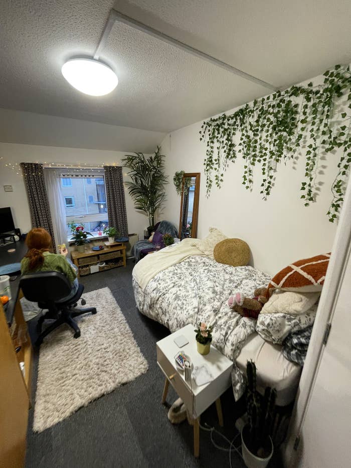 Female university student eating in her room with plants