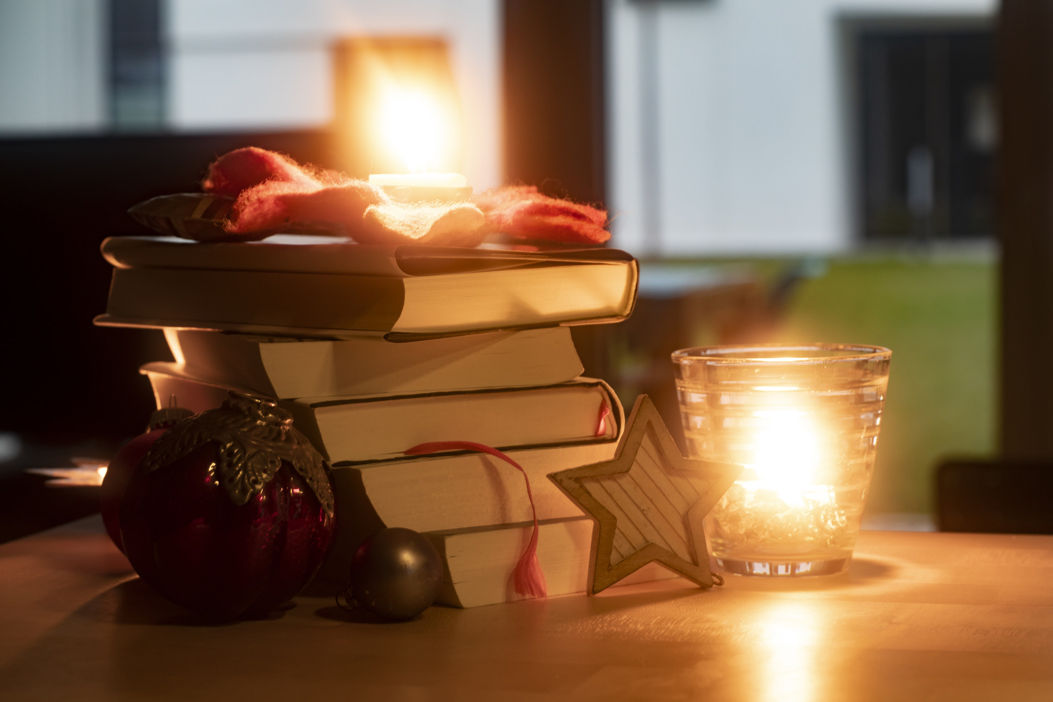 Stack of books next to a candle